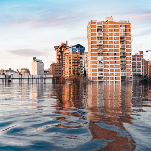 Commercial buildings surrounded by floodwater illustrating commercial casualty insurance, property damage, business risk management, and loss prevention.
