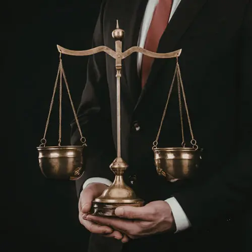Businessman in a suit holding golden scales of justice, representing market conduct and agent blunders in the insurance industry